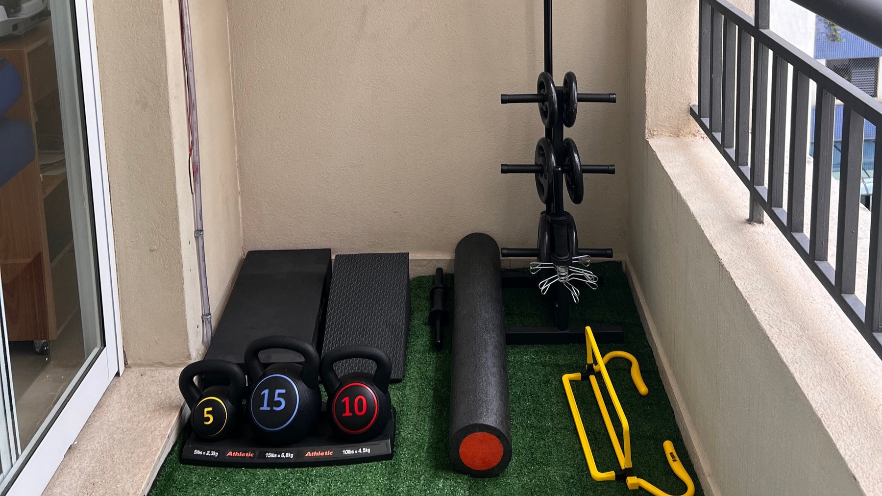 Área de exercícios com kettlebells, rolo e barras