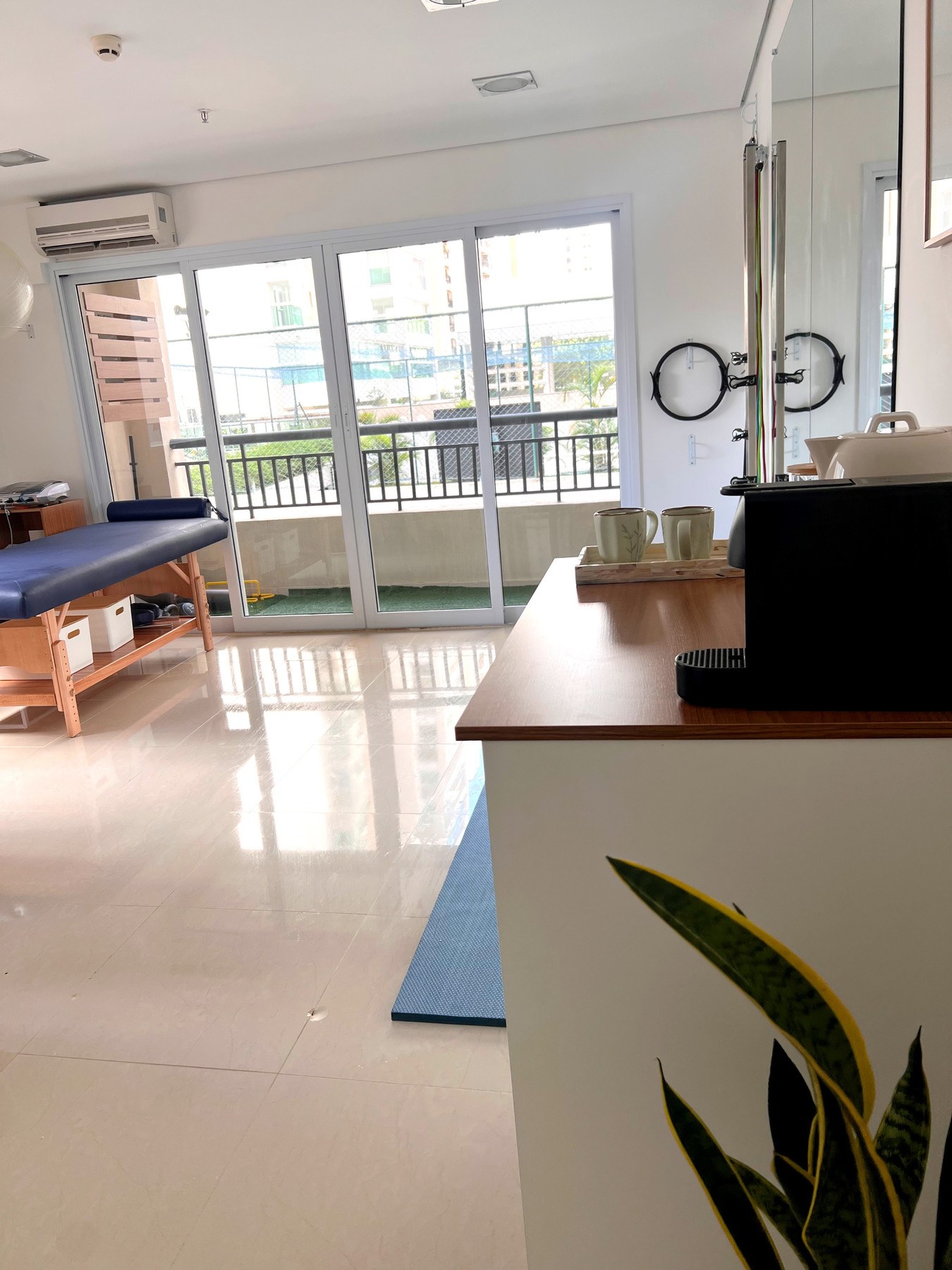 Sala de atendimento com maca e área de exercícios